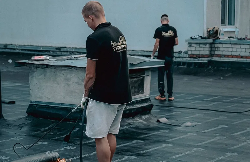 Roofing crew working on a commercial flat roof