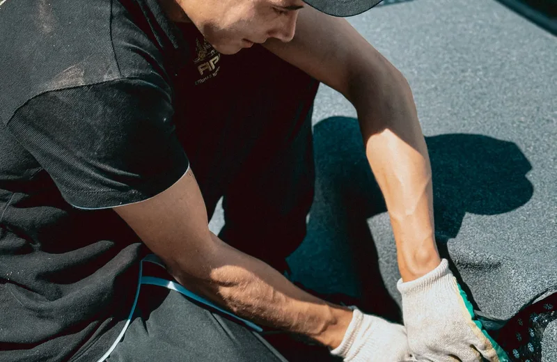 Roofer repairing roofing material by hand